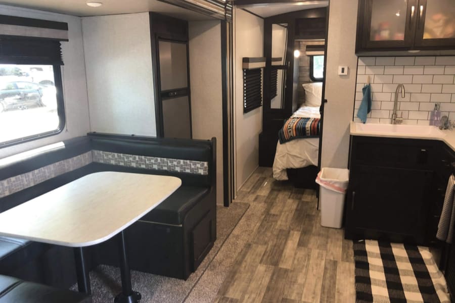 RV rental interior view: dining area, kitchen, and bedroom suite. All the comforts of home on wheels.