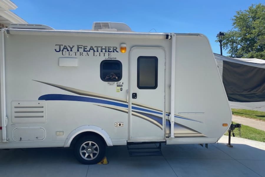 Jayco Jay Feather Ultra Lite RV travel trailer, ready for your next rv rental adventure. Side view with spare tire.