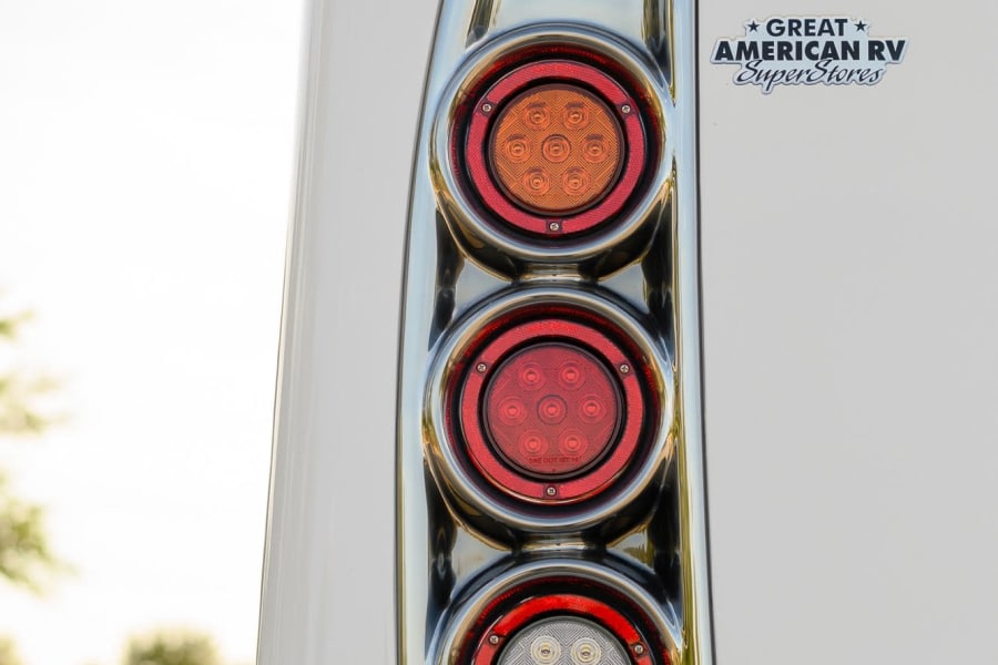 Close-up of an RV rental's rear LED taillights and "Great American RV SuperStores" logo on its white body.