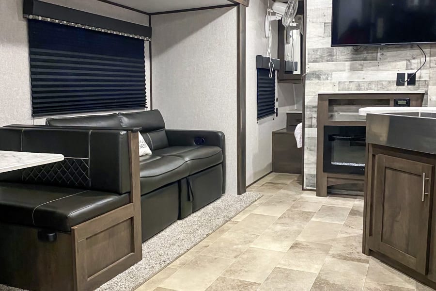 Spacious and modern RV rental interior featuring a comfortable living area, dinette, and kitchen, perfect for travel.
