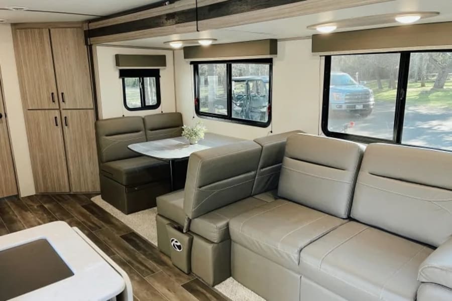 Spacious RV rental interior: a bright living area with a comfortable dinette and a large sofa.