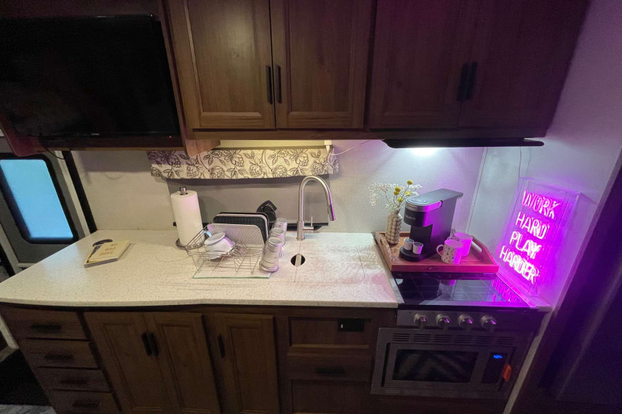 Range, microwave, convection oven and a large fridge.  Two galley sinks and trash under countertop.