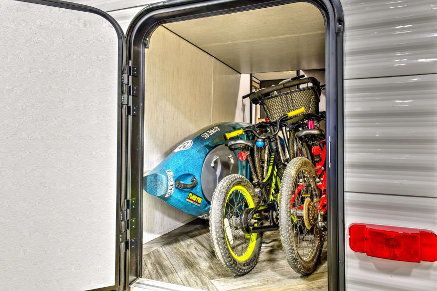 RV rental's spacious storage compartment holds bikes, a kayak, and outdoor gear, perfect for your next adventure.