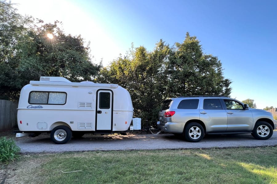 A white Casita travel trailer is hitched to a silver Toyota Sequoia SUV, ready for your next rv rental adventure.