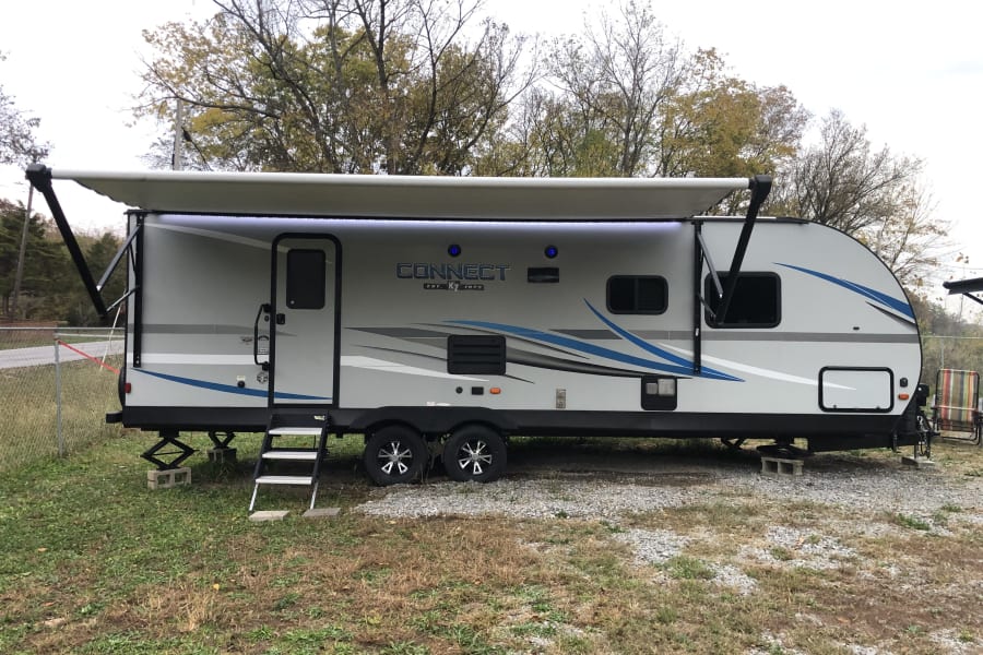 This spacious Connect RV rental shows its extended awning with LED lights, ready for your next travel trailer adventure.
