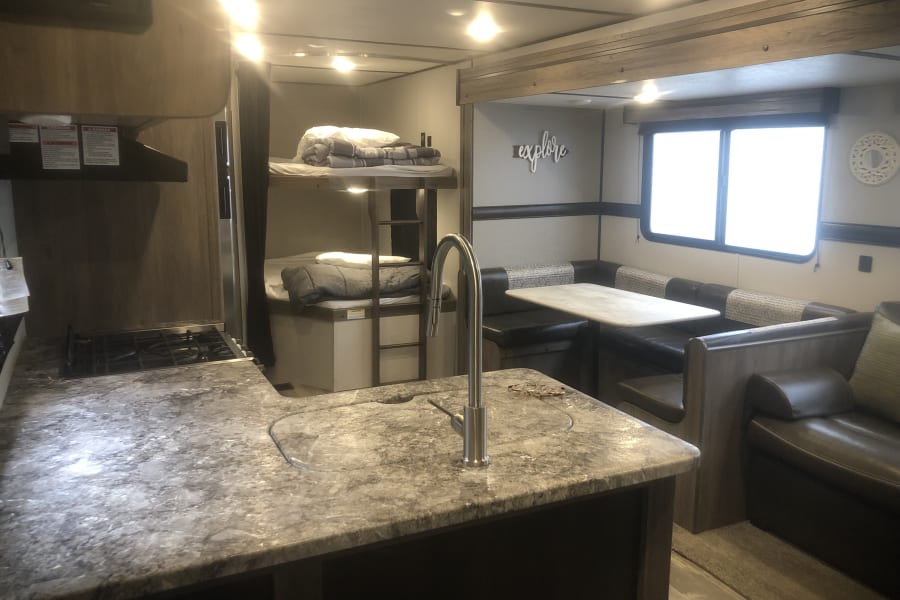 Spacious living space.  View from door.  Kitchen, couch to the immediate right, horseshoe dining table and seating, double sized bunk beds.  All linens and pillows are provided.