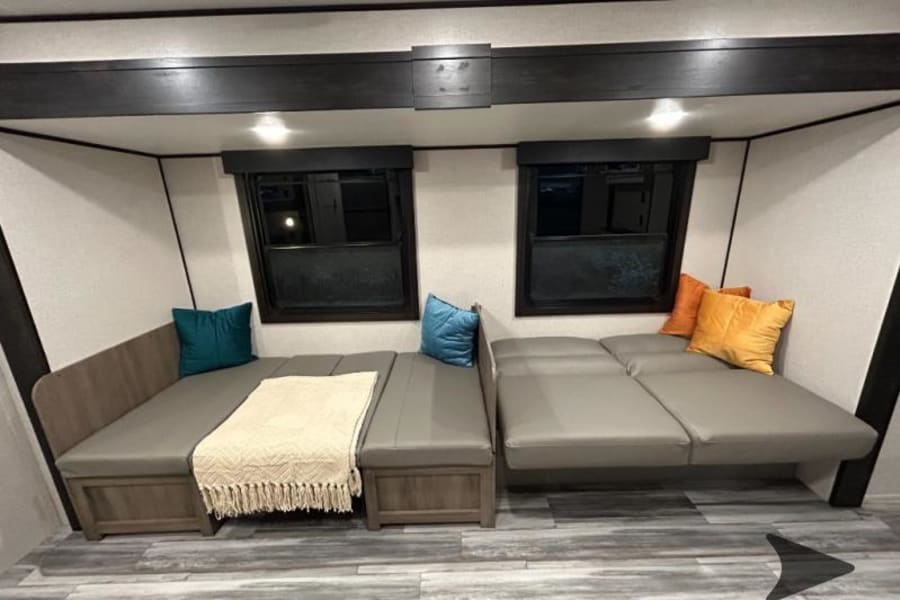 Spacious RV rental interior with modular seating and cozy cushions, ideal for relaxation.