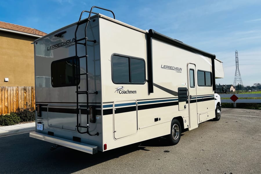 This cream Coachmen Leprechaun RV rental, with a rear ladder for roof access, is ready for your next motorhome adventure.