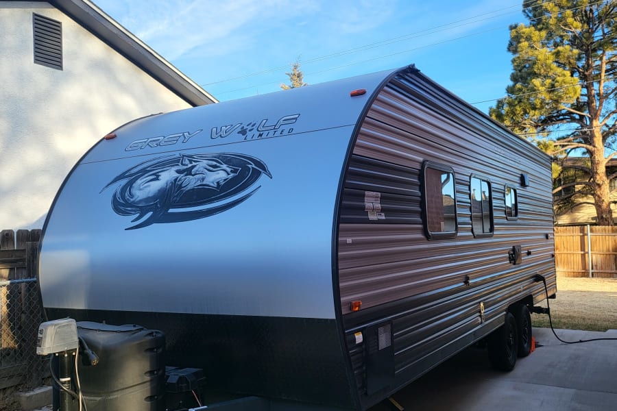 Grey Wolf Limited travel trailer, perfect for RV rental, parked outdoors under a bright blue sky.