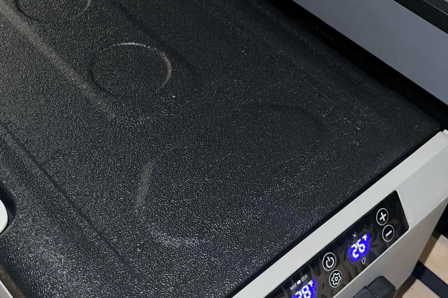 A portable fridge/freezer, set to 28&deg;F, neatly integrated into an RV rental setup, perfect for road trip cooling.