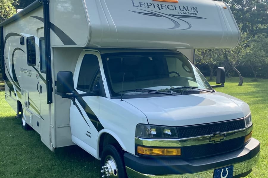 White Coachmen Leprechaun Class C RV rental, parked on lush grass, ready for your next travel adventure.