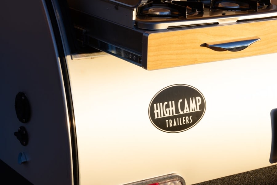 Explore with an **rv rental**! This High Camp teardrop trailer reveals its Dometic outdoor kitchen, ready for your next adventure.