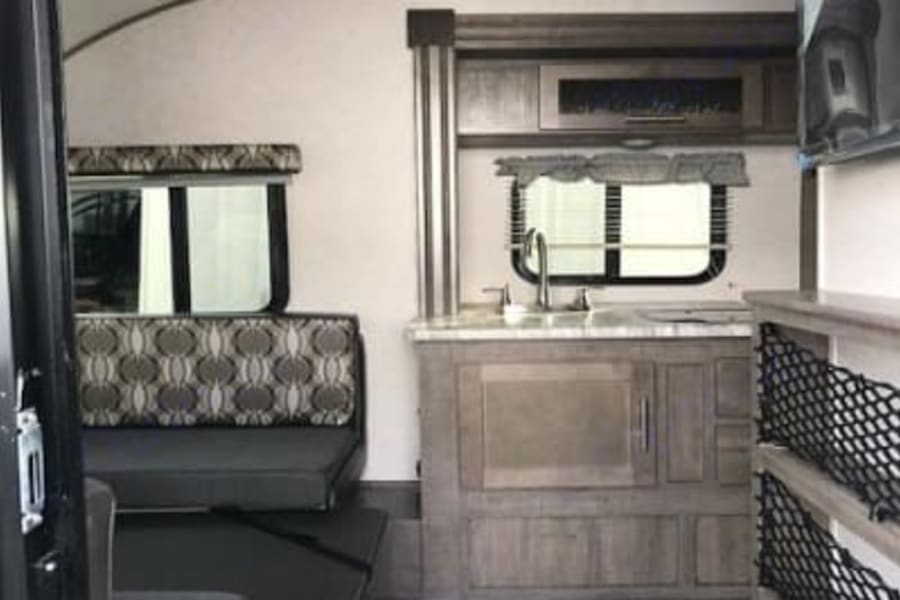Sink, 4 burner stove, microwave, stocked with pots/pans, plates/bowls, utensils, cooking utensils, cups, coffee press.
