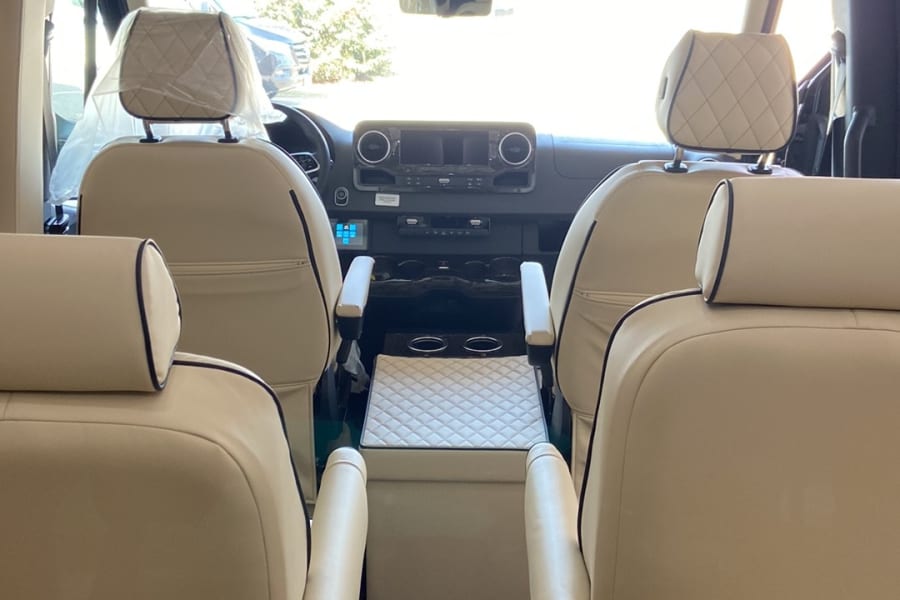 Spacious luxury RV rental interior with premium leather seats, an entertainment system, and a comfortable design for your journey.
