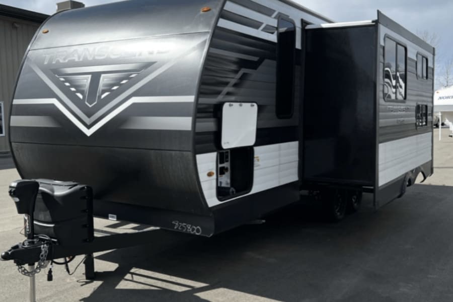 This sleek black & white Transcend travel trailer with extended slide-out is ideal for your next RV rental adventure.