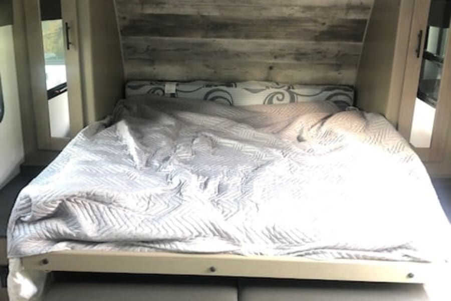 RV rental bedroom with a space-saving murphy bed over seating, ample overhead storage, and mirrored closets.