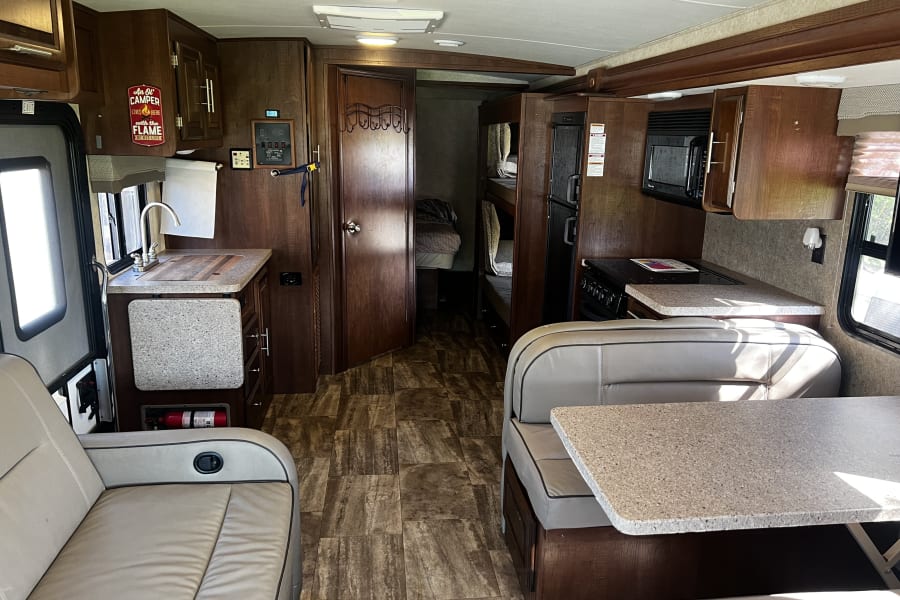 Spacious RV rental interior with modern kitchen, living area, and dinette, ideal for a comfortable trip.