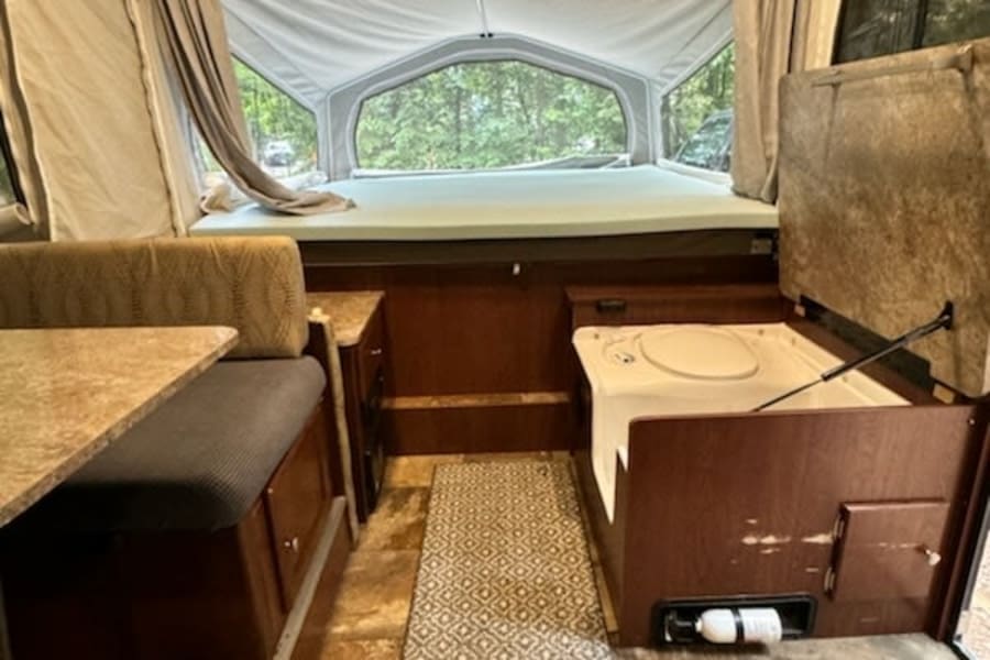 Step inside this RV rental! Features include a pop-up bed with scenic views, dinette, and portable toilet.