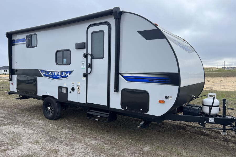 This sleek, gray travel trailer with blue accents is ready for your next RV rental adventure!