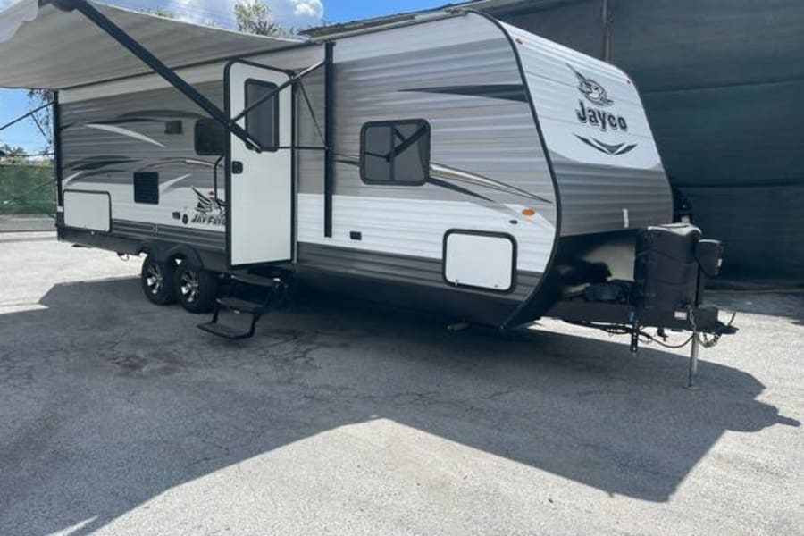 Spacious Jayco travel trailer for rv rental, featuring an extended awning and outdoor steps.