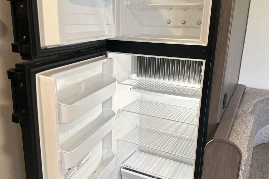 RV rental: An open, empty Dometic RV refrigerator/freezer combo, with some frost in the top section.