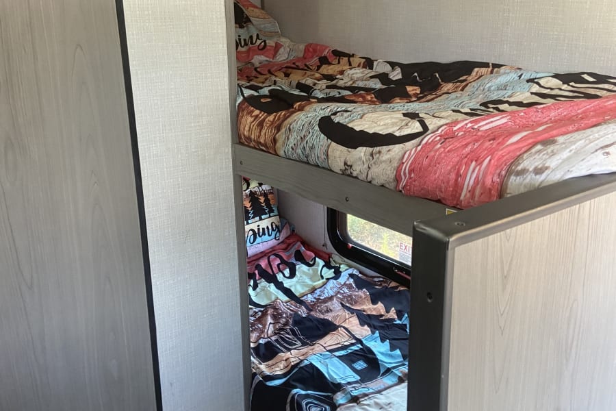 RV rental bunk beds provide a cozy, compact sleeping area with a window, perfect for family adventures.