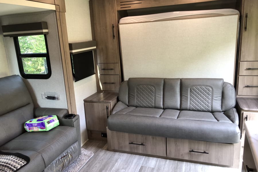 Bed folded up showing couch and one of recliners