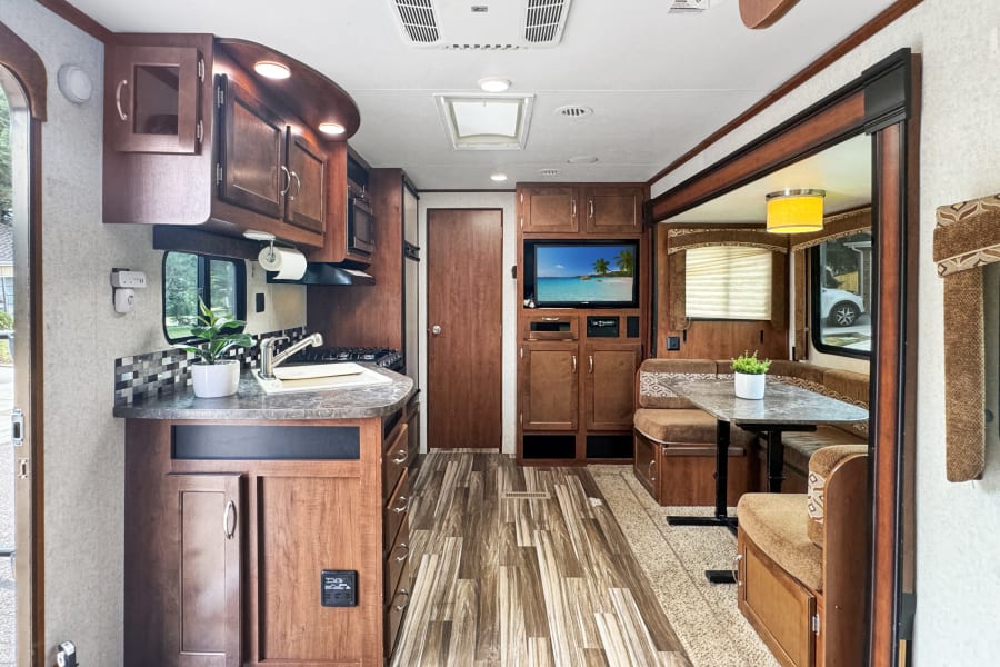 Enjoy this RV rental's well-appointed kitchen, comfortable dinette, and entertainment center.