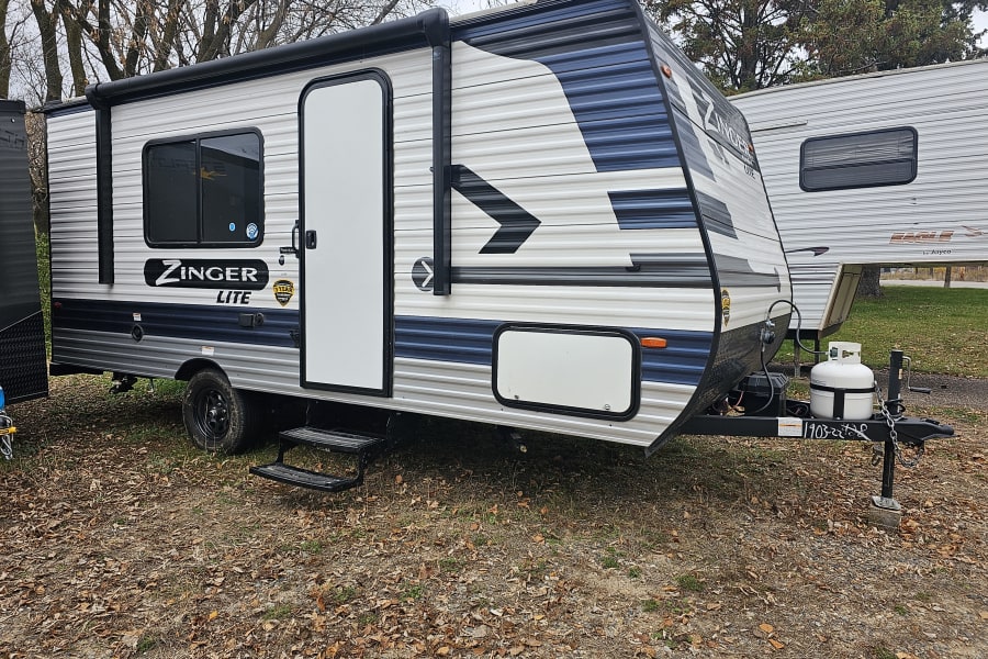 This Zinger Lite travel trailer, with its white & blue exterior, is a fantastic RV rental option.