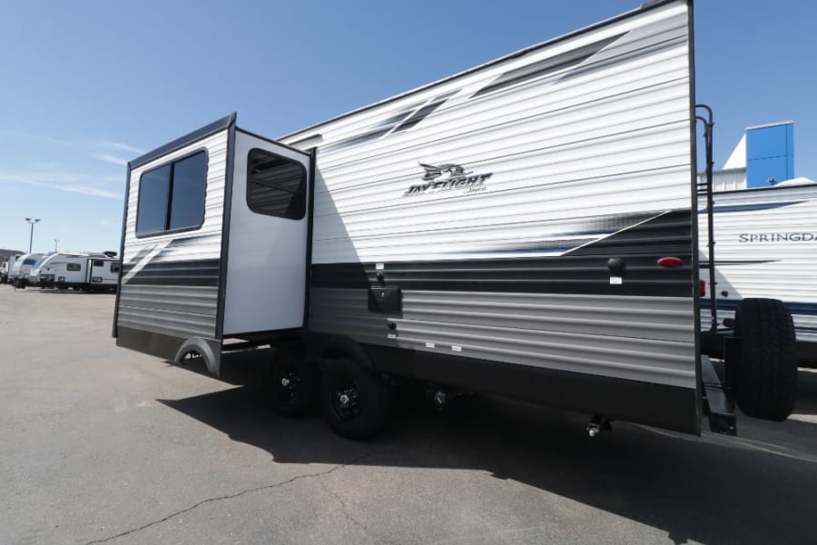 Jayco Jay Flight travel trailer RV rental with a side slide-out extended, parked on a lot. Ready for adventures!