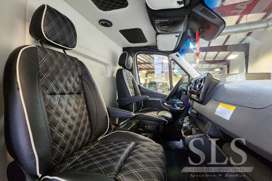 Luxury RV rental: Plush, diamond-stitched leather seats in a high-end custom van interior.