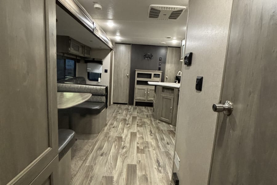 Step inside this modern RV rental! Features include a cozy dinette, well-equipped kitchen, and stylish wood-look flooring.