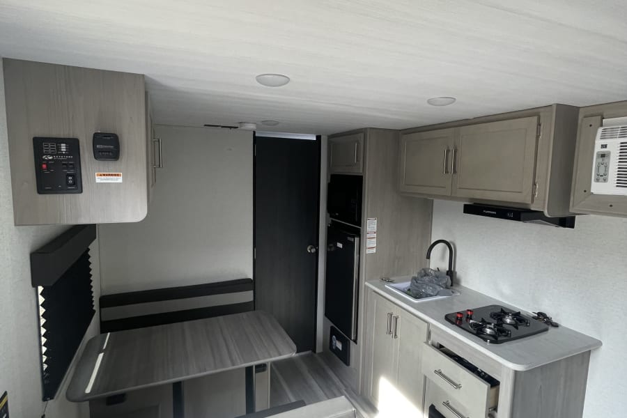Step inside this clean, modern RV rental, featuring a full kitchen and spacious dining area.