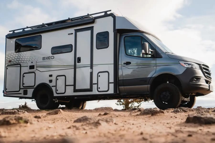 A rugged gray EKKO RV on rocky terrain, ideal for your next rv rental adventure.