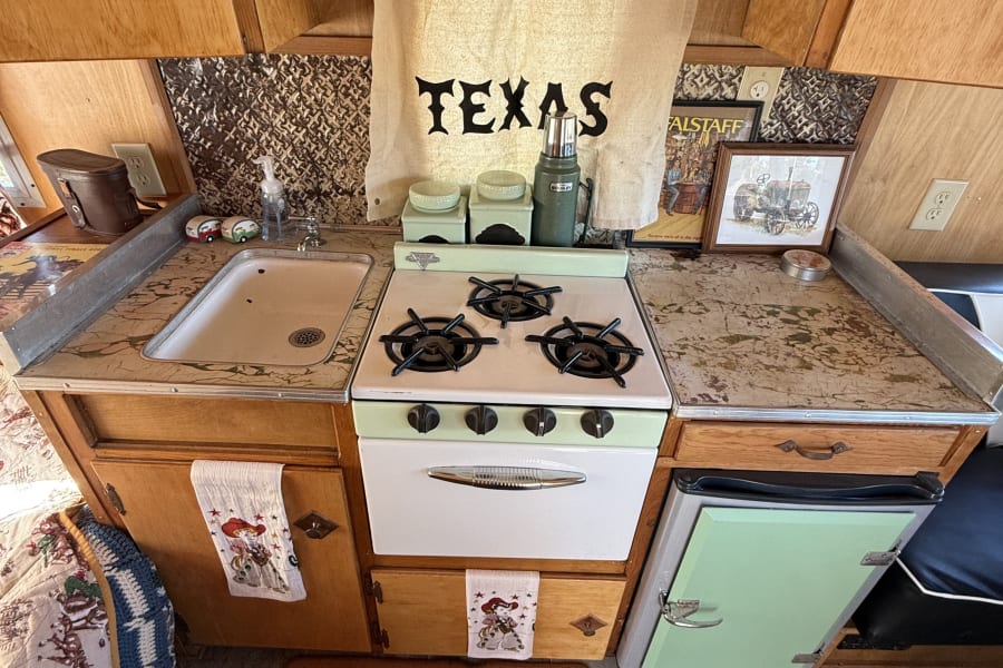 Everything you see in this picture is original! The sink with its hardware, the stove, and the door on the fridge! The fridge used to be an icebox, in order to update the Camper we upgraded to an electric fridge , but in order to keep the classic charm, we kept the original door of the icebox and placed it on the refrigerator! The cabinets and drawer/door pulls and countertop are all original.