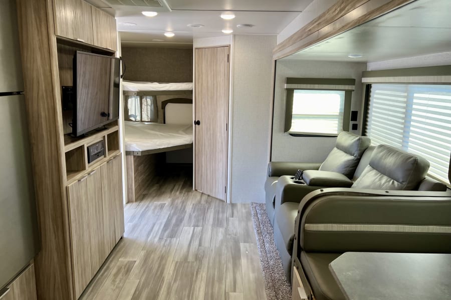 Two full-size bunks and a flatscreen TV with dual recliners