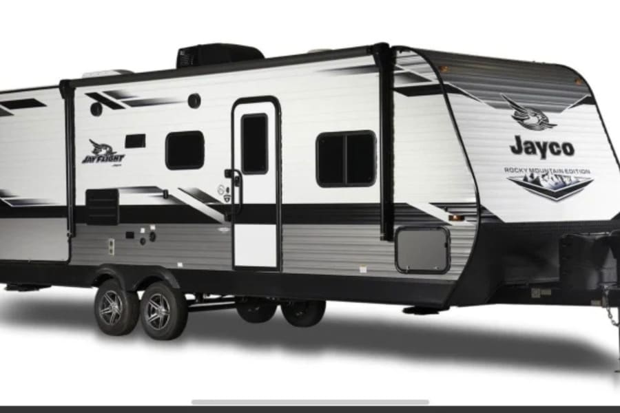 White and black Jayco travel trailer, a spacious RV rental option for camping and outdoor trips.