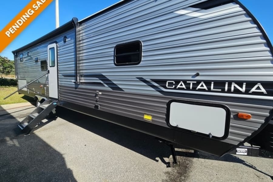 Side view of a grey Catalina travel trailer with steps extended. Perfect for your next RV rental getaway.