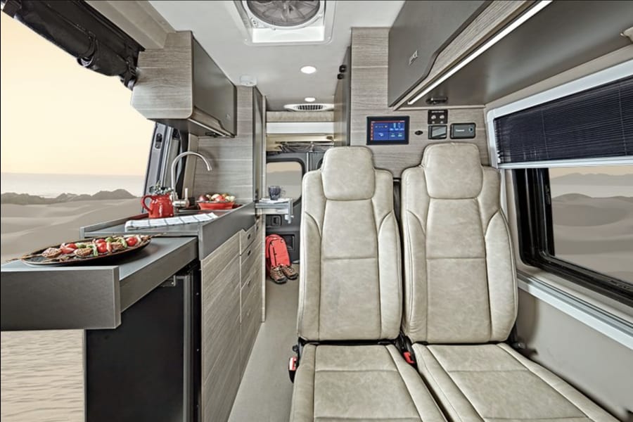 Explore the desert in comfort with this luxurious RV rental. Features a full kitchenette and plush seating for your next adventure.