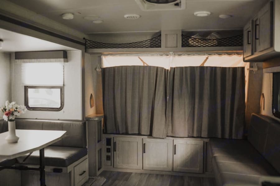 Spacious RV rental interior featuring a cozy dinette, sofa, and clever storage solutions for comfortable travels.