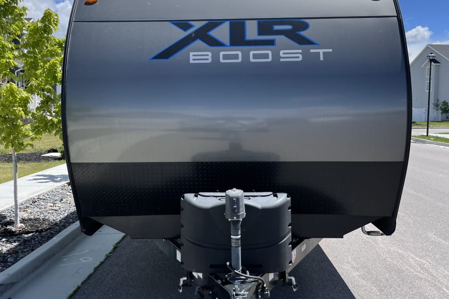 Brightly lit front of a grey XLR Boost toy hauler/travel trailer. Consider this RV for your next rv rental adventure.