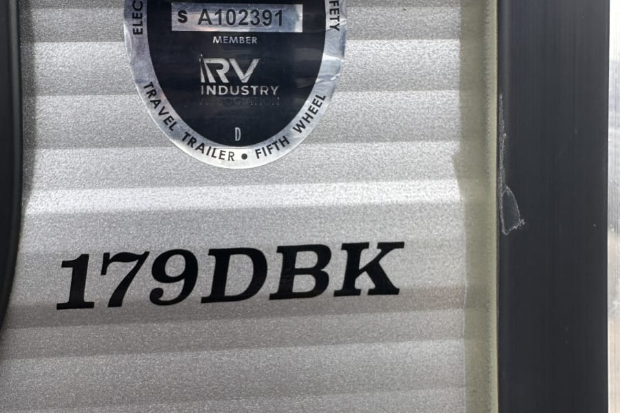 Details on an RV rental: Compliance seal, model 179DBK, and safety caution for stabilizing the travel trailer.