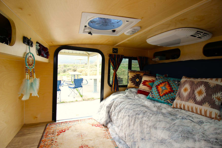 The beg conveniently folds into a couch for day use. This makes storing things in the trailer easier. Shown is our glamping bedding option.