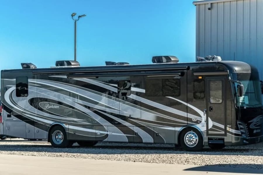 Sleek Berkshire motorhome, a spacious RV rental, with dark and silver graphics, parked outside.
