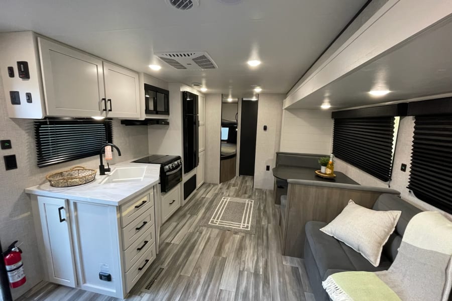 Spacious RV rental interior with modern white kitchen