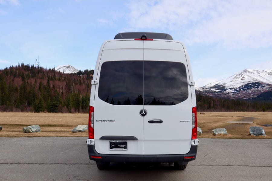 Rear view of a white Mercedes Sprinter van. Perfect for rv rental trips to explore mountains & nature.