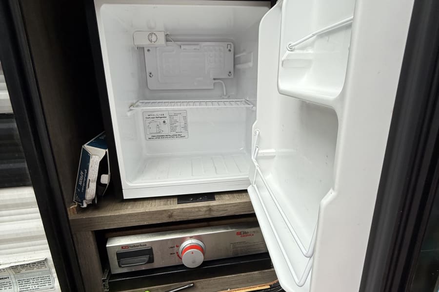 This RV rental offers an outdoor kitchen: a CoolLogic mini-fridge and a Suburban griddle for convenient camping.