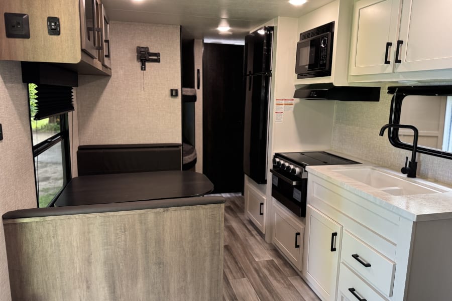 Spacious and modern RV rental interior featuring a full kitchen, dining area, and comfortable living space.
