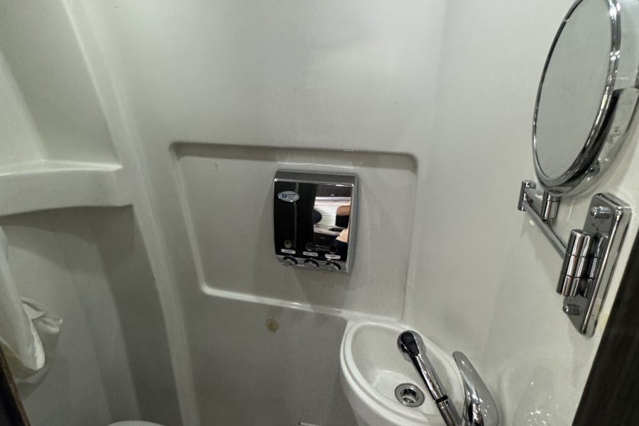 Compact RV rental wet bath featuring toilet, sink, and shower. Ideal for space-saving travel.