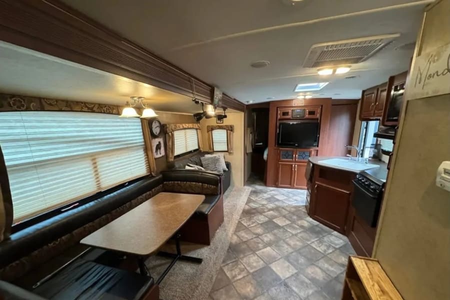 An RV rental's inviting interior: dinette, lounge, full kitchen, and entertainment center offer comfort on the road.